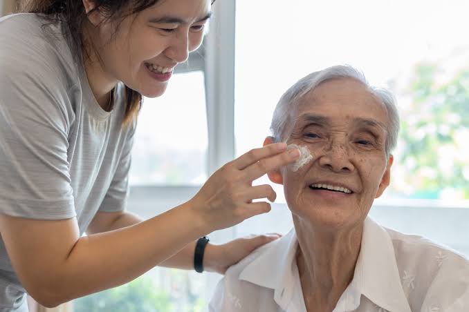 Patient attendant helping a patient at home